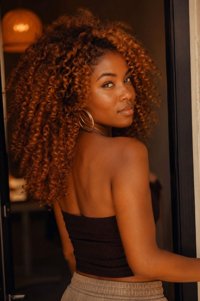 Rich amber copper fall hair color with glossy curls